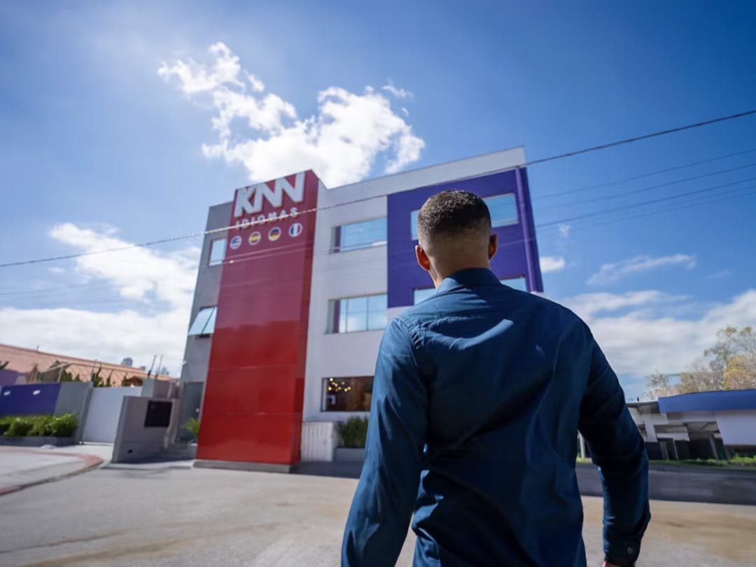 Homem olhando a fachada da escola KNN