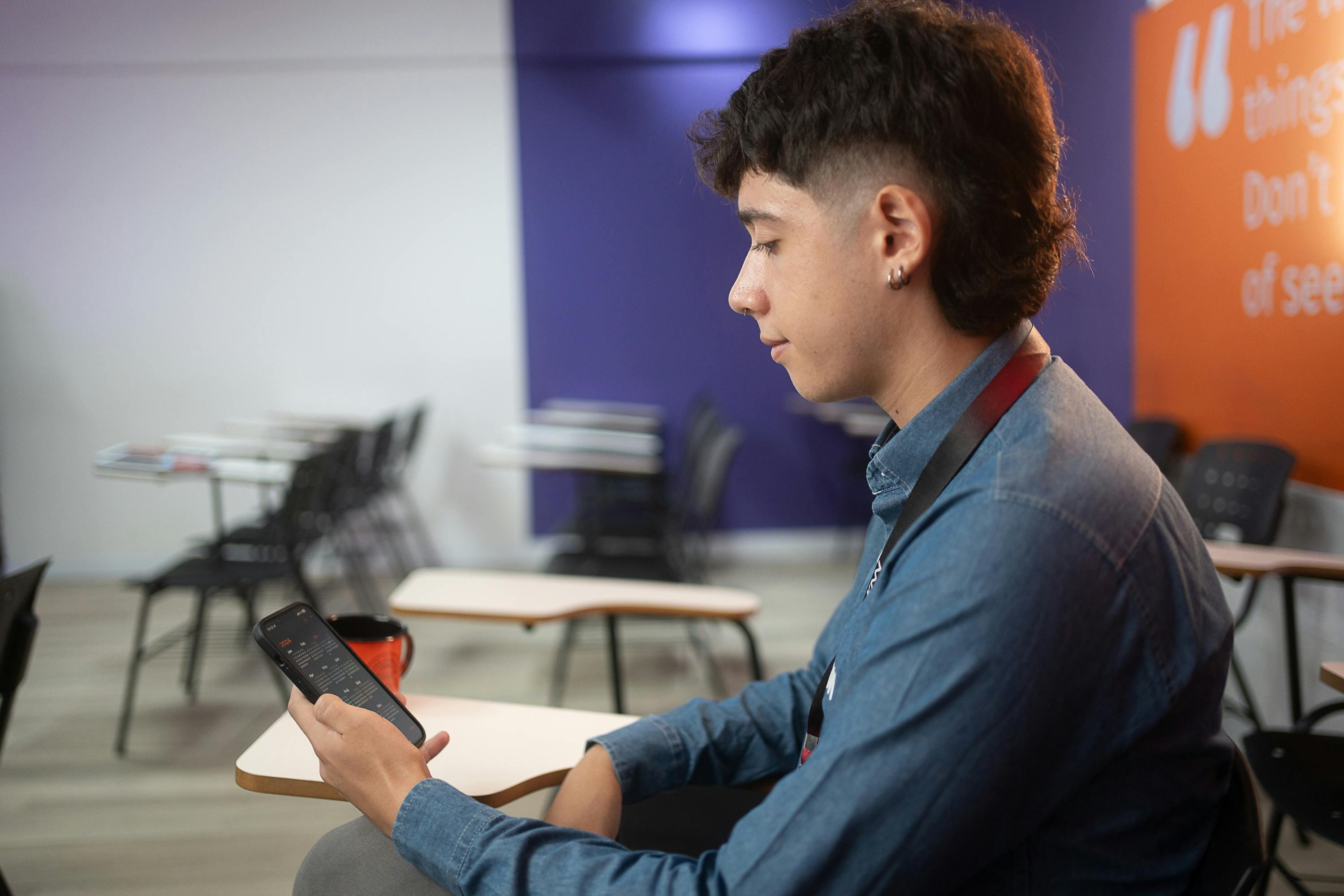 Homem usando o celular na sala de aula